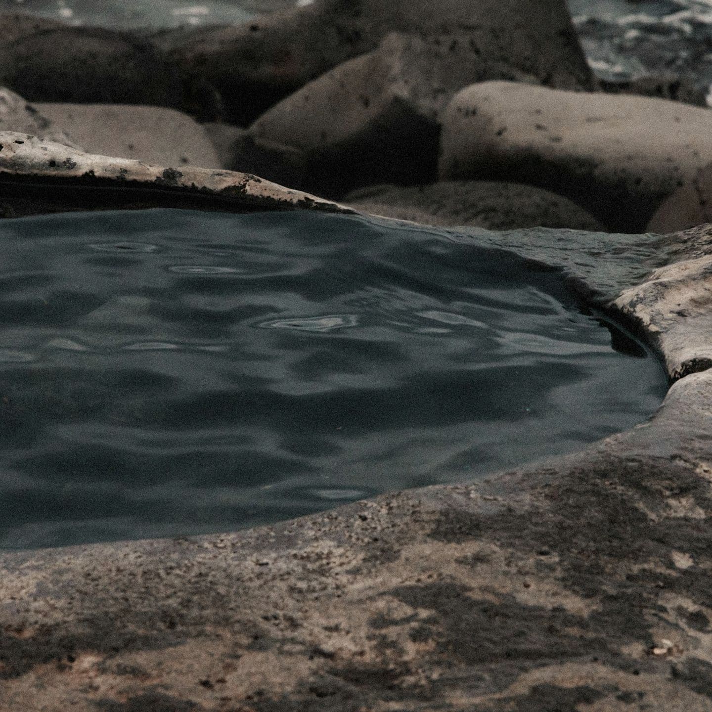 Купель с тёмной водой в скальной породе